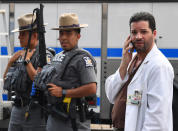 <p>A hospital staff member talks on his phone as he walks past police outside the Bronx-Lebanon Hospital as they respond to an active shooter north of Manhattan in New York on June 30, 2017. (Timothy A. Clary/AFP/Getty Images) </p>