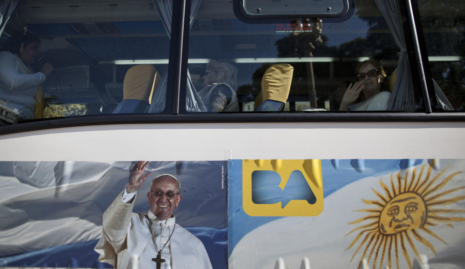 In this May 11, 2013 photo, passengers sit in the single-story cruiser tour bus decorated with a banner of Pope Francis and the Argentine flag in Buenos Aires, Argentina. With an Argentine on the throne of St. Peter, the South American country's capital city has launched a series of guided tours. Three-hour weekend bus trips and walking tours are so far non-commercial in the first step at papal tourism. The bus tours wind through Buenos Aires twice each Saturday and Sunday and can carry about 40 passengers, cruising past 24 sites linked to the new pope. There's no charge for the trip, or for more limited walking tours of downtown and neighborhood sites Tuesdays and Thursdays. (AP Photo/Natacha Pisarenko)