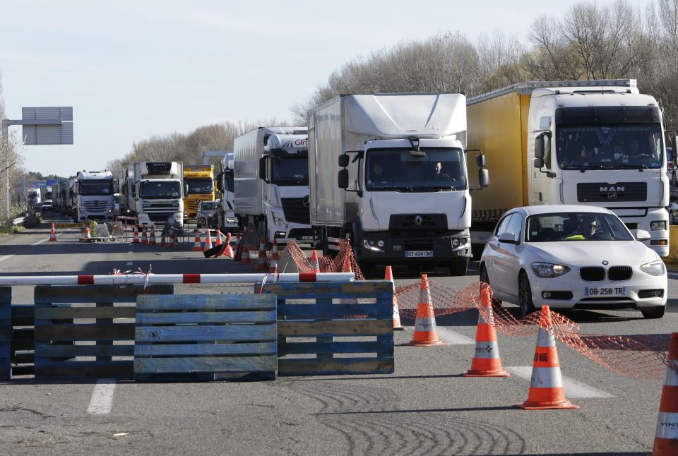 Trucks and cars line up at a toll gate as demonstrators open the toll gates on motorway near Aix-en-Provence, southeastern France, Tuesday, Dec. 4, 2018. French Prime Minister Edouard Philippe announced a suspension of fuel tax hikes Tuesday, a major U-turn in an effort to appease a protest movement that has radicalized and plunged Paris into chaos last weekend. (AP Photo/Claude Paris)
