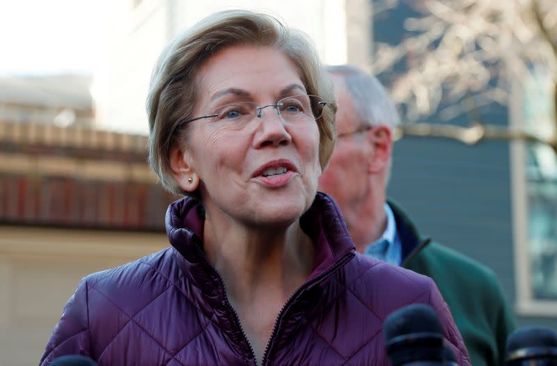 FILE PHOTO: Senator Elizabeth Warren talks to reporters after telling her staff she is withdrawing from 2020 U.S. presidential race outside her home in Cambridge, Massachusetts