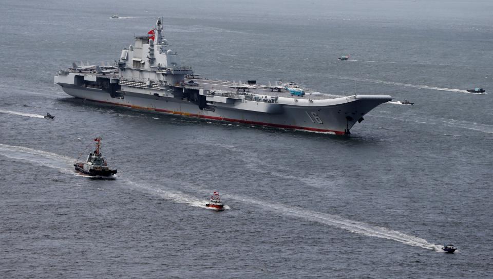 Liaoning, China's first aircraft carrier, is escorted through the sea by several smaller ships