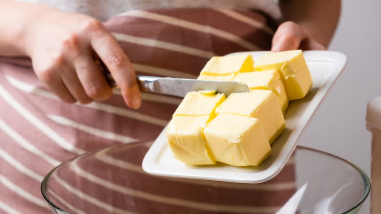 Person transferring butter into bowl