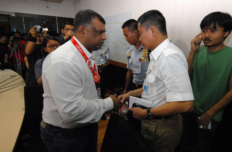 AirAsia boss Tony Fernandes (L) speaks with the Indonesian Minister of Transport Ignatius Jonas at the airport in Jakarta as search operations for missing AirAsia flight continue