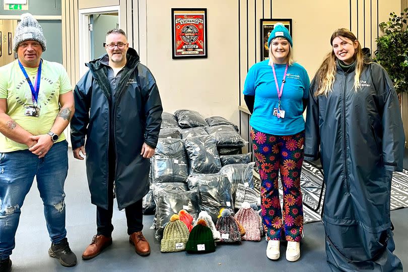 John Keogh, second left, presents his Ootsider coats to staff at Streetwork . The coats were bought by Edinburgh city council for the charity