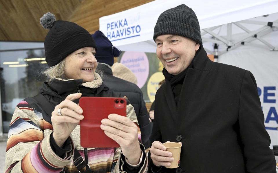 Member of Greens Party, presidential candidate Pekka Haavisto, right, has a photo taken with Outi Vaajoensuu during campaigning in Helsinki, Finland on Dec. 16, 2023. The first round of the Finnish presidential election will take place on January 28. (Vesa Moilanen/Lehtikuva via AP)