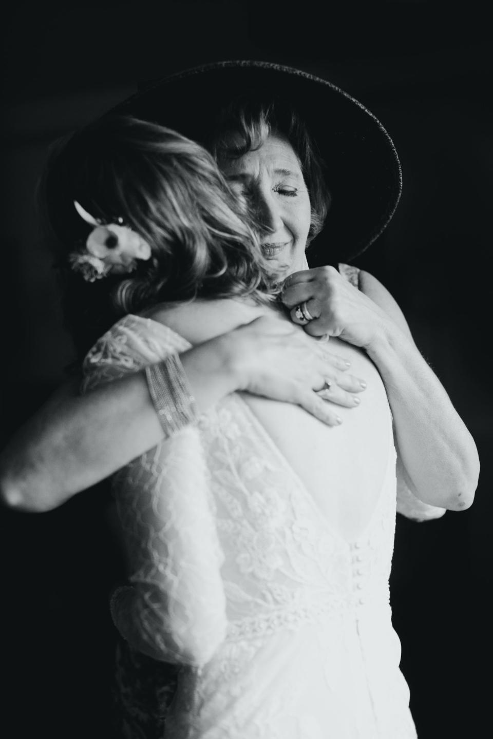 A bride embraces her mother on her wedding day.