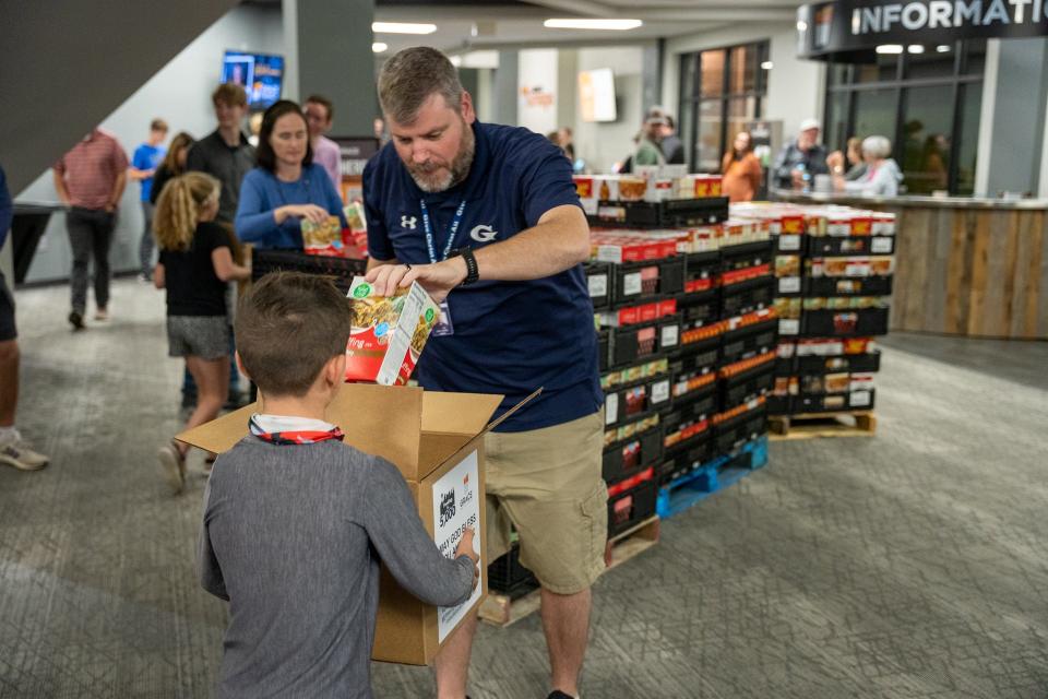 Head of Schools Dr. Tony Pointer packs a box with stuffing at the Feed the 5,000 packing party held at Grace Baptist Church Wednesday Nov. 17, 2021.