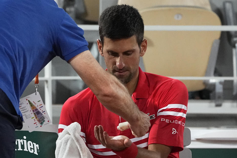 Serbia's Novak Djokovic gets some cream in his hand during a break as he plays Italy's Matteo Berrettini in a quarterfinal match of the French Open tennis tournament at the Roland Garros stadium Wednesday, June 9, 2021 in Paris. (AP Photo/Michel Euler)