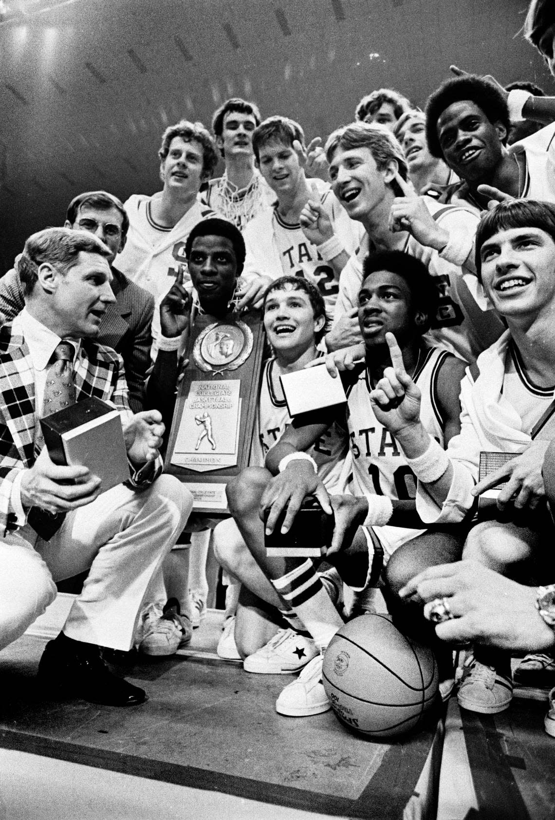 NC State players pose with coach Norm Sloan and the 1974 National Championship trophy after defeating Marquette.