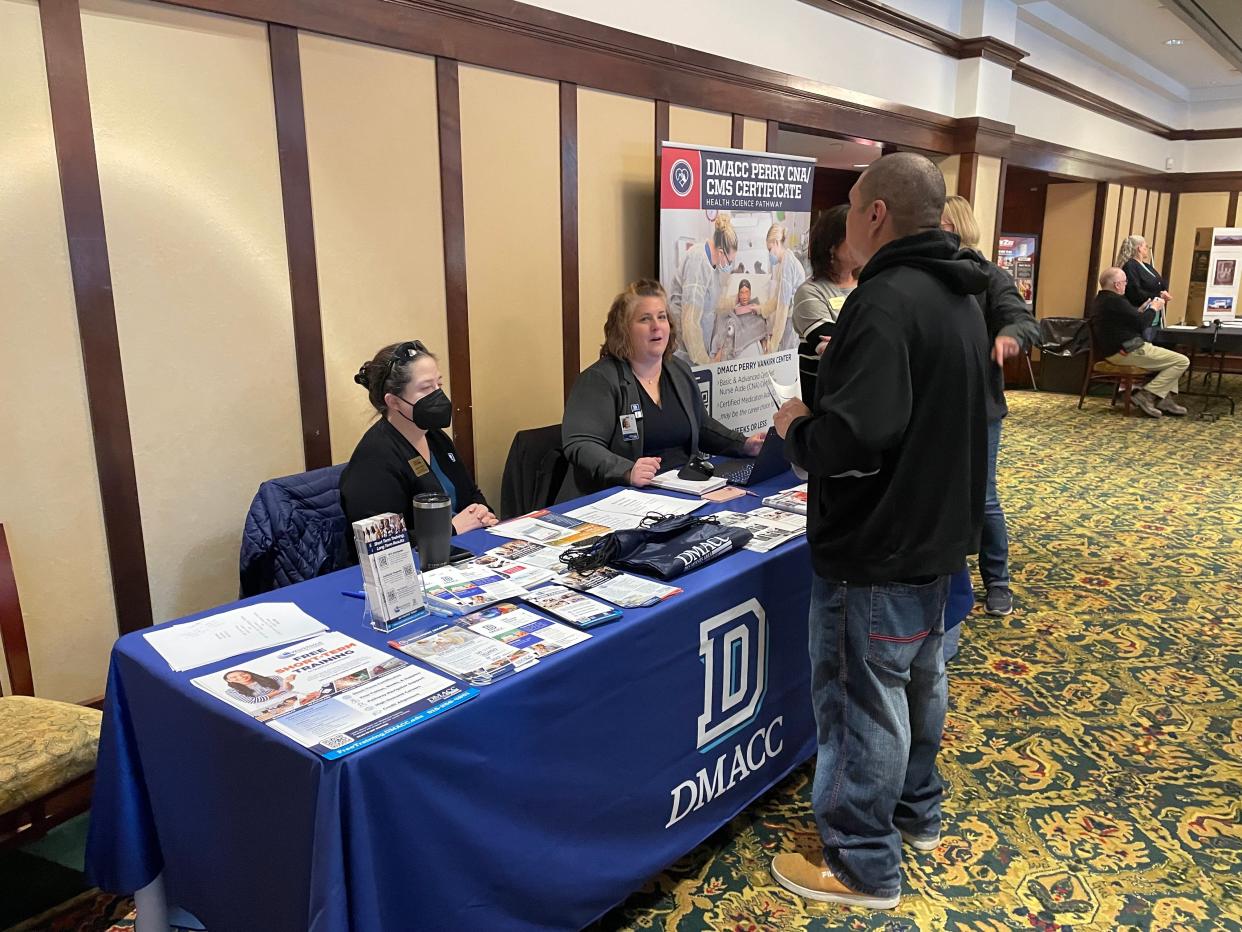 Attendees stop at the DMACC table during a job fair on Wednesday, April 3, 2024, at the Hotel Pattee in Perry.