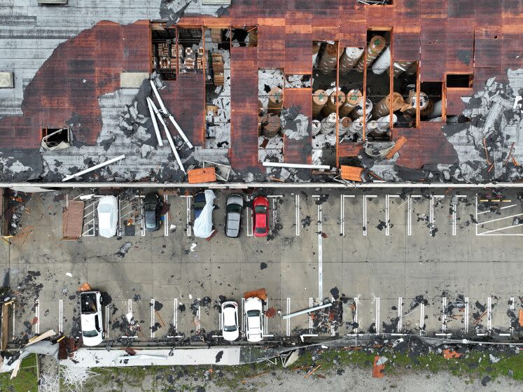 Montebello, CA - March 22: Crews start to clean up debris after a strong microburst -- which some witnesses dubbed a possible tornado -- heavily damaged several cars and buildings, including the roof of the Royal Paper Box Company, shown in photo, in Montebello Wednesday, March 22, 2023. Video from the scene showing portions of rooftops being ripped off industrial structures and debris swirling in the air. The National Weather Service on Tuesday night issued a brief tornado warning in southwestern Los Angeles County, but it was allowed to expire after about 15 minutes when weather conditions eased. There was no such warning in place late Wednesday morning when the powerful winds hit Montebello, near the area of Washington Boulevard and Vail Avenue. (Allen J. Schaben / Los Angeles Times)