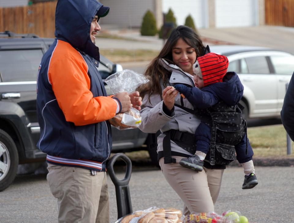 Gabriela and Brian Godoy feed their one-year-old son, Elian, bread after visiting a Food Bank of the Rockies food distribution in Denver on Dec. 19, 2019. The Trump administration is changing food stamp requirements in a move that poverty experts say will increase demand on food banks nationwide.