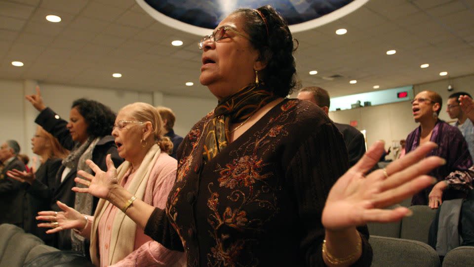 Maria Antonetty, foreground right, joins other worshipers at a Spanish Easter service at the Primitive Christian Church in New York. The fastest growing segment of evangelicals in the US are Latino Americans. - Tina Fineberg/AP