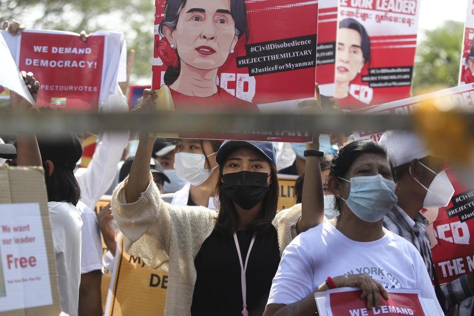 An anti-coup protester holds up a poster with an image of deposed Myanmar leader Aung San Suu Kyi during a rally outside the Central Bank of Myanmar building in Yangon, Myanmar on Monday, Feb. 15, 2021. Myanmar's military leaders have extended their detention of Suu Kyi, whose remand was set to expire Monday and whose freedom is a key demand of the crowds of people continuing to protest this month's military coup. (AP Photo)