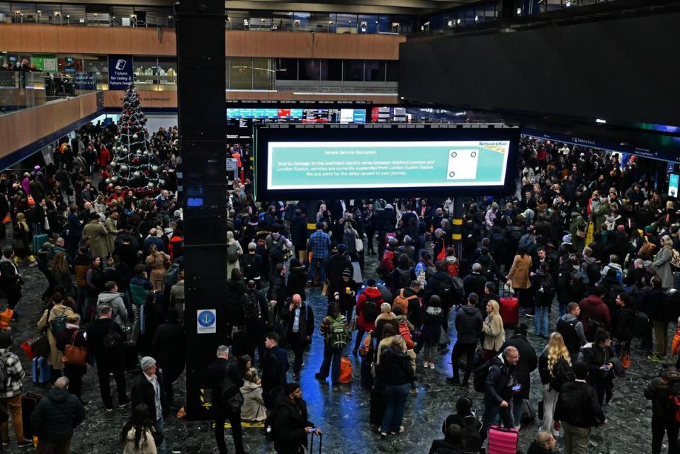 Rail travellers stand beneath empty departures boards at Euston on Thursday as the chaos unfolds (Justin Tallis/AFP via Getty Images)