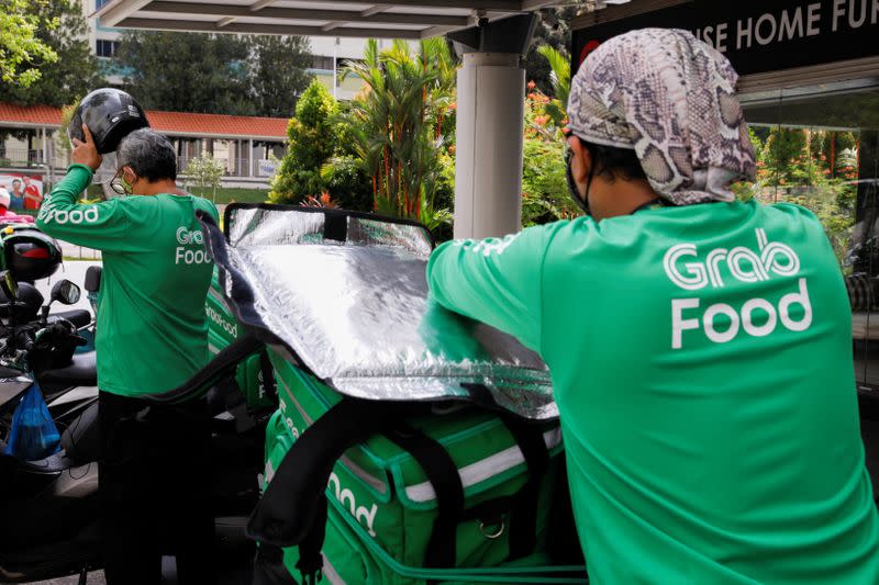 Food delivery riders get ready for a delivery outside a shopping mall, amid the coronavirus disease (COVID-19) outbreak in Singapore