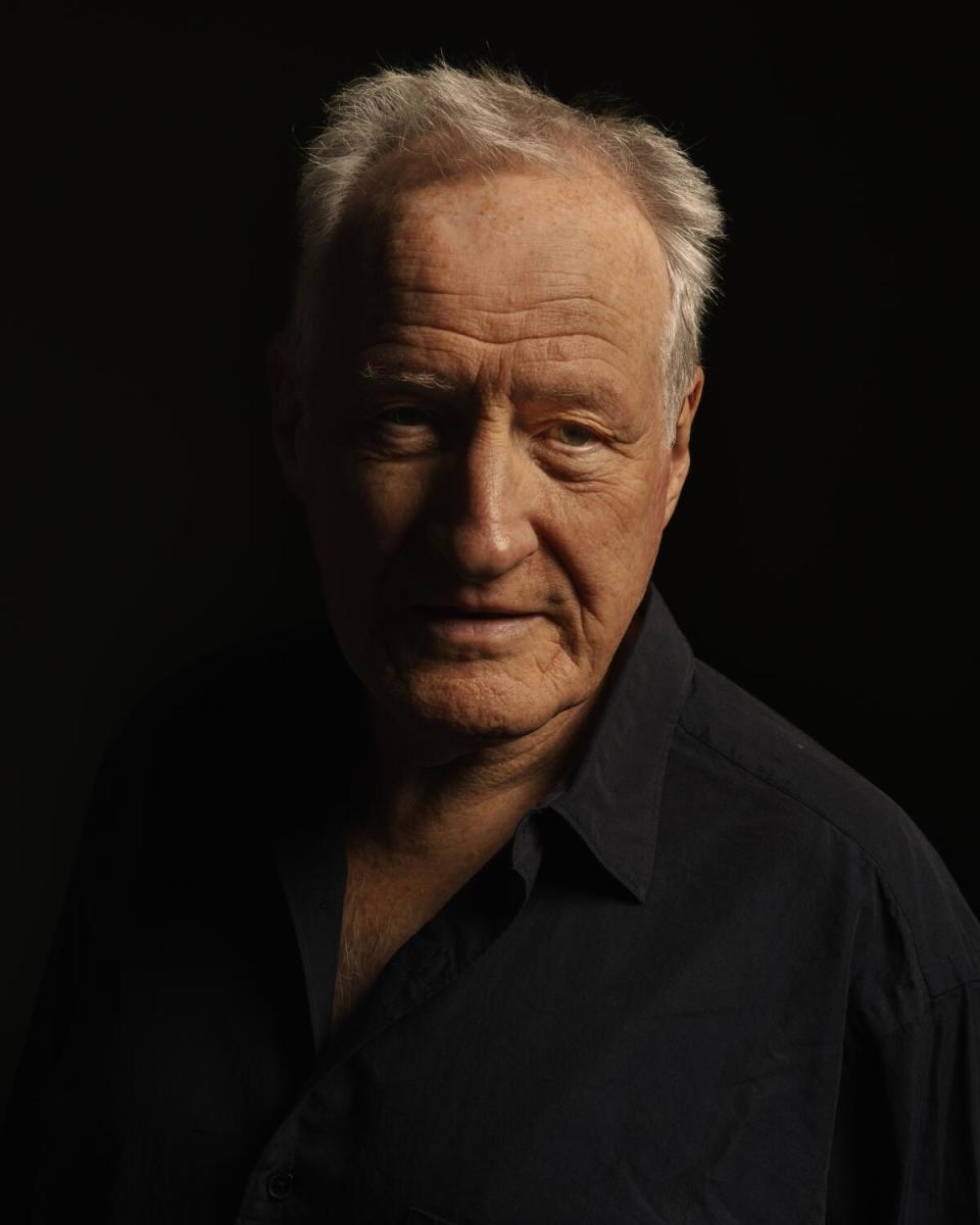 A man in a black shirt poses for the camera.