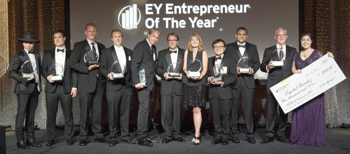 jeff green, trade desk CEO, fourth from left, wearing a black suit, holding an award, next to 10 other people