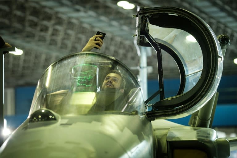 A man takes a selfie sitting in the cockpit of a Swedish-made SAAB Gripen E fighter mockup during the LAAD 2017 Defence and Security expo, in Rio de Janeiro