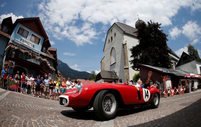 FILE PHOTO: Former English Formula One driver Stirling Moss waves to spectators while seated in a 1955 Ferrari 750 Monza during the Ennstal Classic rally near Groebming