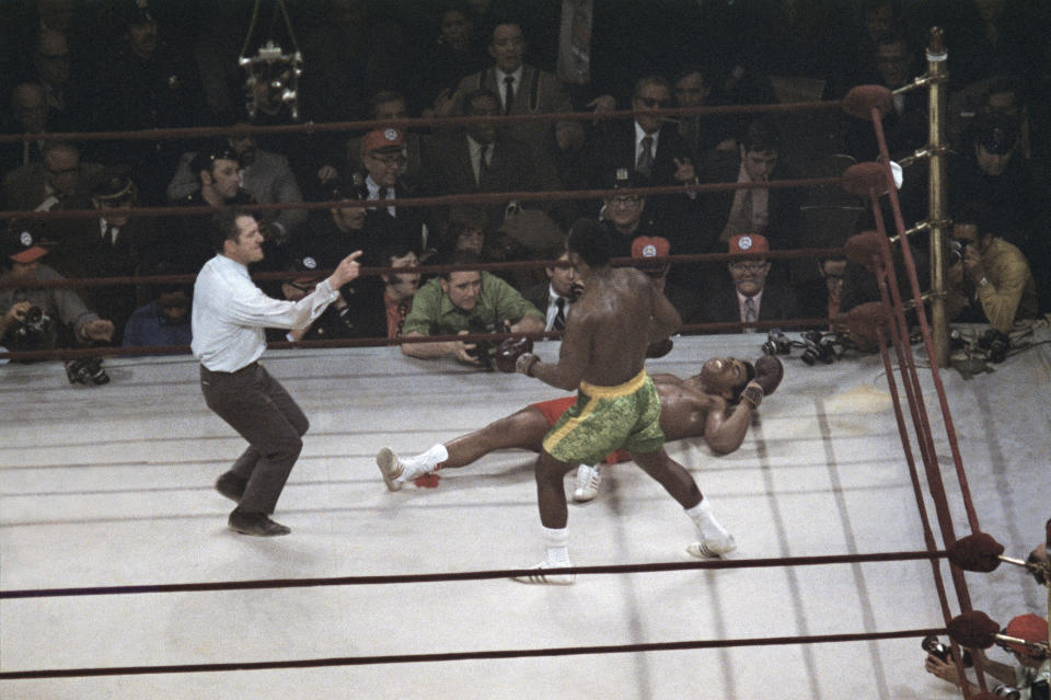 FILE - Joe Frazier stands over Muhammad Ali as referee Art Mercante gestures in the 15th round of their boxing match at Madison Square Garden in New York, in this March 8, 1971, file photo. Frazier was a slight 6-5 favorite in a fight that captivated both the nation and the world. (AP Photo/File)
