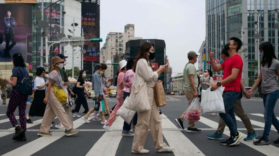 This picture taken on April 14, 2023 shows people walking down a street at the Ximen district in Taipei