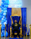 Cloud 9 Cannabis CEO and co-owner Sam Ward Jr. poses in a throne photo-op for customers, Saturday, April 13, 2024, in Arlington, Wash. The shop is one of the first dispensaries to open under the Washington Liquor and Cannabis Board's social equity program, established in efforts to remedy some of the disproportionate effects marijuana prohibition had on communities of color. (AP Photo/Lindsey Wasson)