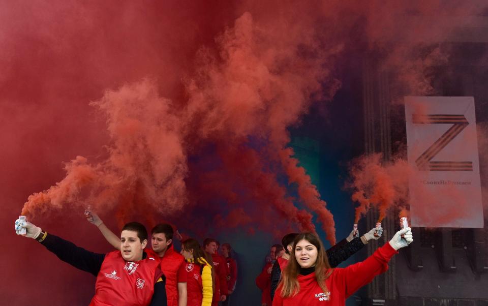 Youths hold flares in front of the Crimean parliament with the letter Z - AP