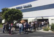 FILE - In this April 28, 2015, file photo, students wait outside Everest College in Industry, Calif., hoping to get their transcripts and information on loan forgiveness and transferring credits to other schools. On Thursday, March 24, 2016, a San Francisco Superior Court judge awarded the state a nearly $1.2 billion default judgment against Corinthian Colleges Inc., the bankrupt operator of for-profit colleges. California on Friday, Sept. 25, 2020, created what supporters called its own nation-leading, state-level version of the federal Consumer Financial Protection Bureau after critics said the Trump administration significantly weakened national protections. (AP Photo/Christine Armario, File)