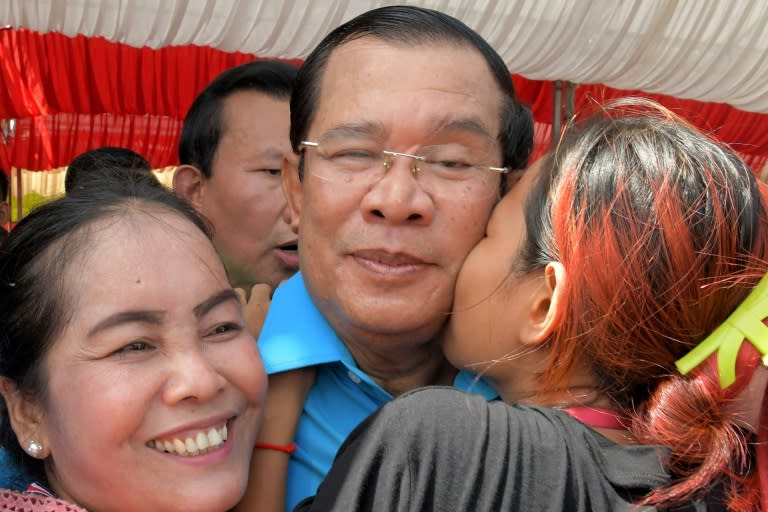 A garment worker kisses Cambodia's Prime Minister Hun Sen during a ceremony at a compound of factories in Phnom Penh, on September 6, 2017