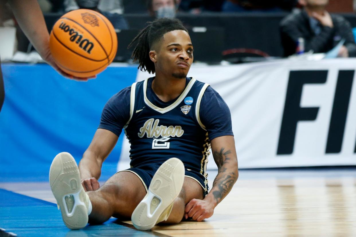 Akron guard Greg Tribble (2) sits on the court after going down during a first-round NCAA college basketball tournament game against UCLA on March 17, 2022, in Portland, Ore.