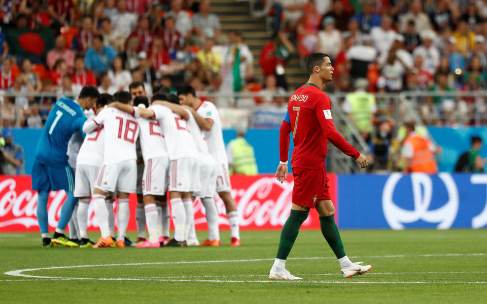 <p>Portugal’s Cristiano Ronaldo waits as Iran players huddle (AP) </p>