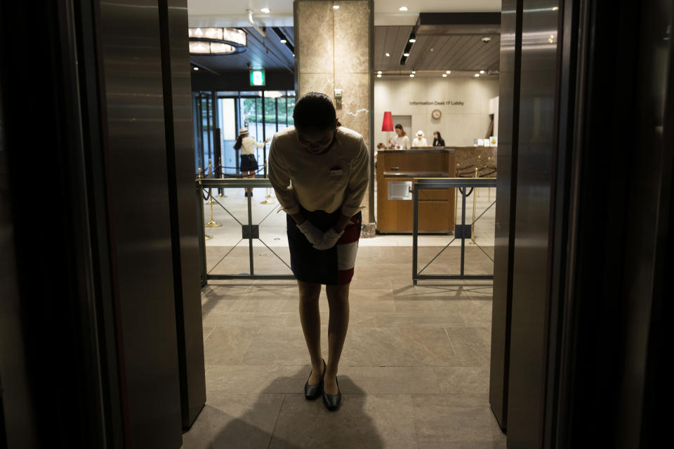 An usher bows to visitors in an elevator going up to Tokyo Tower's observation deck Friday, Sept. 27, 2019, in Tokyo. (AP Photo/Jae C. Hong)