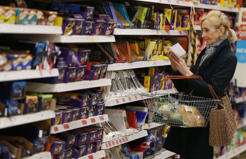 A shopper checks her shopping list in a supermarket in London