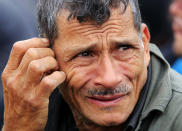 Everado Sanchez from Honduras, an immigrant suspected of being in the country illegally, waits with other immigrants after U.S. Border Patrol agents detained about 75 immigrants who'd been living in hut for several days in a brushy area Thursday April 17, 2014 near North 10 St. and Sprague St. in McAllen, Texas. Agents spent about three hours rounding up the immigrants suspected of being in the country illegally after they responded to the area. Most of the immigrants are believed to be from Central America. (AP Photo/The Monitor, Gabe Hernandez)