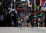 Passersby are seen through a heat haze during hot weather at Sugamo district in Tokyo