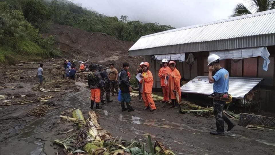 In this image provided by the Department of Public Works and Highways, Mountain Province District Engineering Office, rescuers prepare to dig through the earth to search for survivors after a massive landslide, set off by Typhoon Yutu, crashed down on two government buildings in Natonin township, Mountain Province in northern Philippines Wednesday, Oct. 31, 2018. (DPWH MPDSEO via AP)