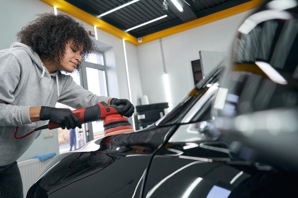 a person buffing a car