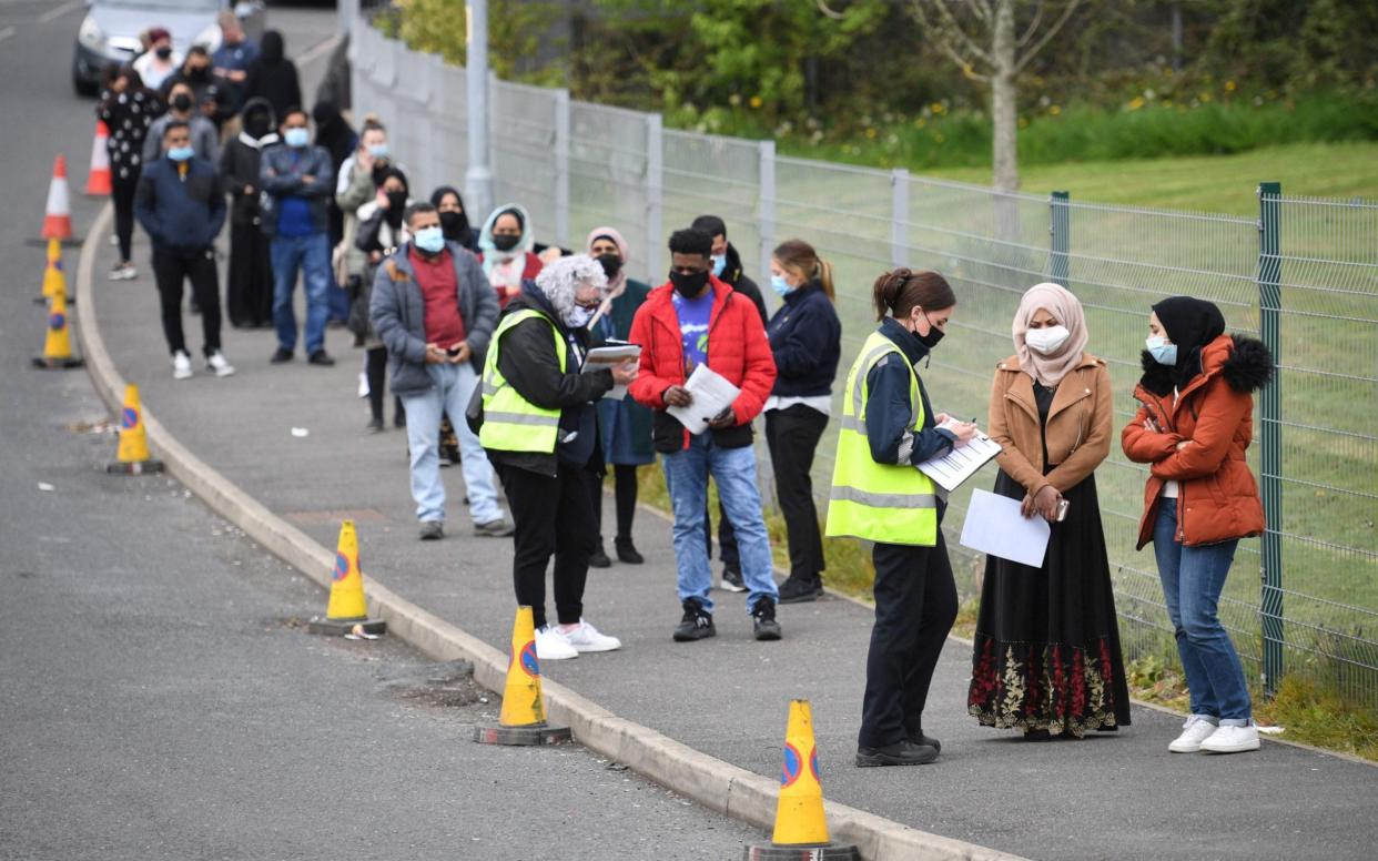 Members of the public queue at a temporary Covid-19 vaccination centre at the Essa academy in Bolton  - Oli Scarff/AFP