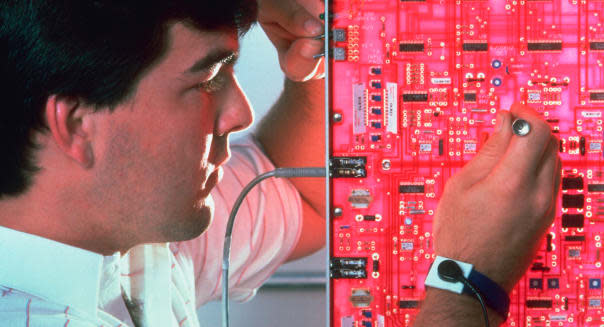 Cellular telephone technician at work on circuit board in Syracuse New York