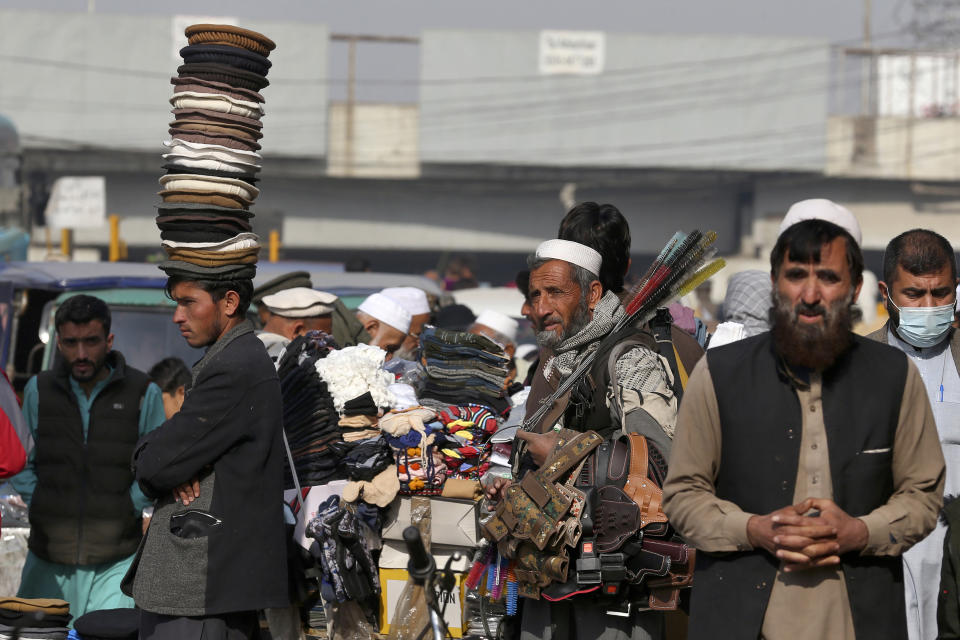 Vendedores ambulantes buscan clientes a lo largo de una calle en la zona antigua de Peshawar, Pakistán, el miércoles 1 de febrero de 2023. (AP Foto/Muhammad Sajjad)