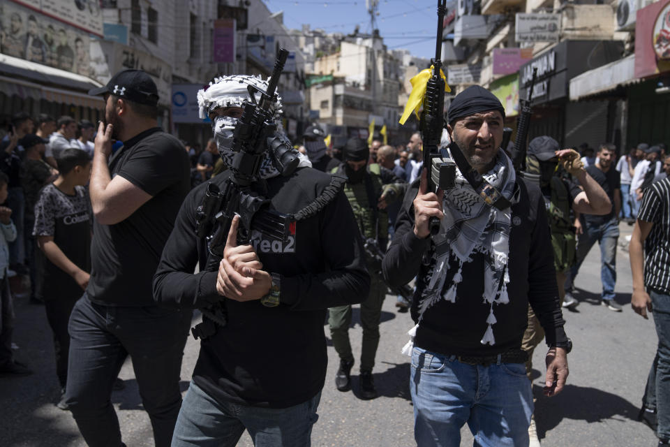 Palestinian militants from the Lions' Den group take part in the funeral procession of three comrades who were killed by Israeli forces, Hassan Qatnani, Moaz al-Masri and Ibrahim Jabr, in the West Bank city of Nablus, Thursday, May 4, 2023. The killing of Zuhair al-Ghaleeth last month, the first slaying of a suspected Israeli intelligence collaborator in the West Bank in nearly two decades, has laid bare the weakness of the Palestinian Authority and the strains that a recent surge in violence with Israel is beginning to exert within Palestinian communities. (AP Photo/Nasser Nasser)