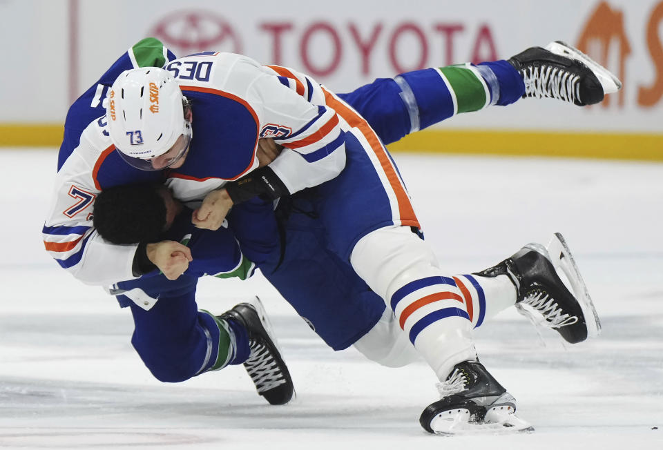 Vancouver Canucks' Dakota Joshua, bottom, and Edmonton Oilers' Vincent Desharnais fight during the first period of an NHL hockey game Wednesday, Oct. 11, 2023, in Vancouver, British Columbia. (Darryl Dyck/The Canadian Press via AP)