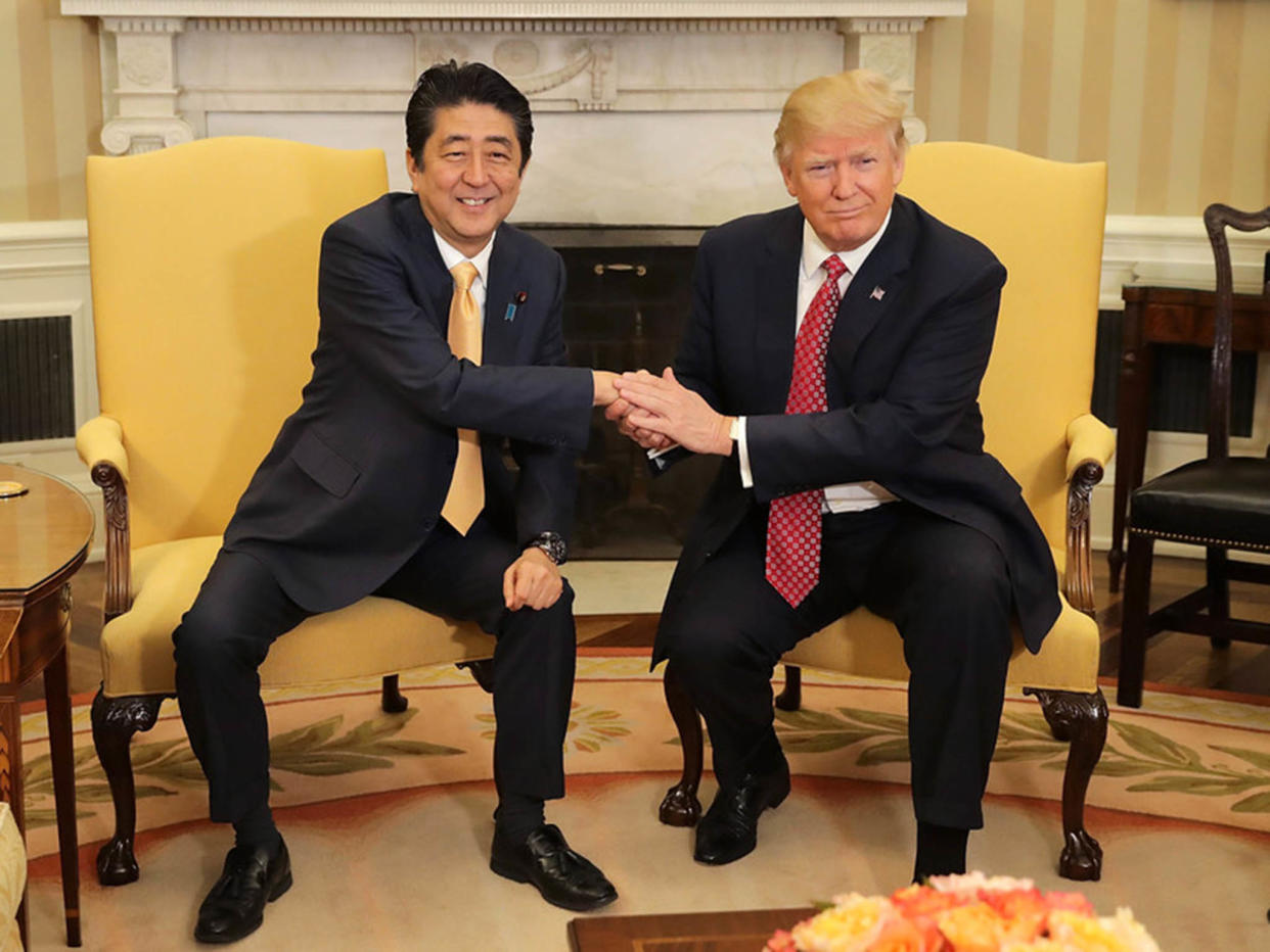 Patting down: the Donald held Japanese PM Shinzo Abe’s hand for a gruelling 19 seconds: EPA