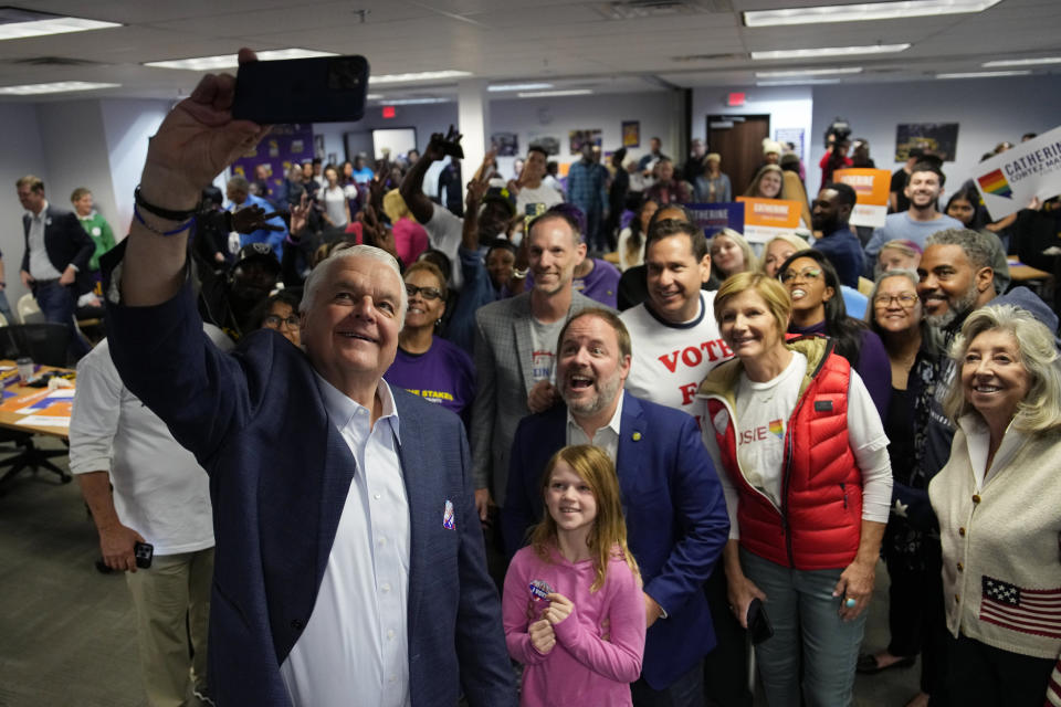 Nevada Gov. Steve Sisolak, left, takes a selfie with other candidates and supporters during a campaign event Tuesday, Nov. 8, 2022, in Las Vegas. (AP Photo/John Locher)