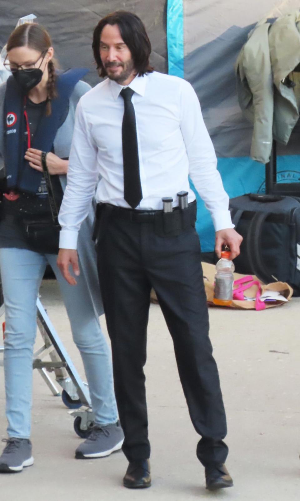 <p>Keanu Reeves takes a break from filming to grab a drink on the set of <em>John Wick 4</em> in Paris on Oct. 9. </p>