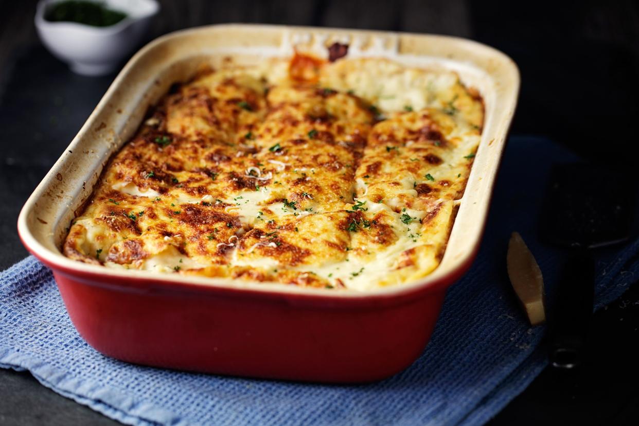 Ravioli Lasagna in red baking dish on a blue dish cloth