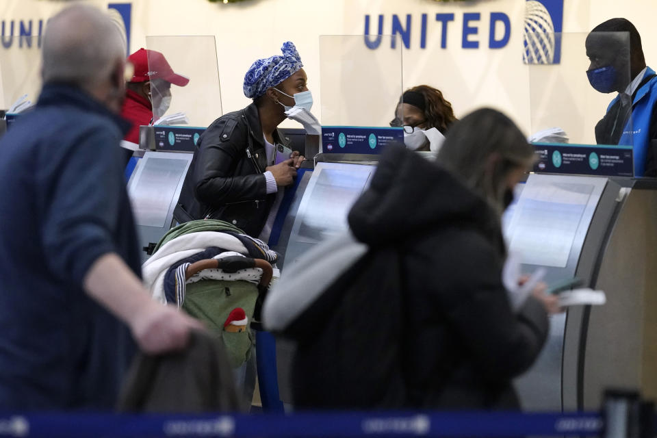 Travelers check in at the airline ticket counters at O'Hare International Airport in Chicago, Thursday, Dec. 30, 2021. (AP Photo/Nam Y. Huh)