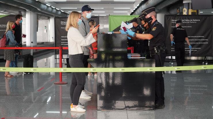 Die Polizei überprüft die Ausweispapiere von Passagieren, die gerade auf dem Flughafen Palma de Mallorca angekommen sind. Foto: dpa