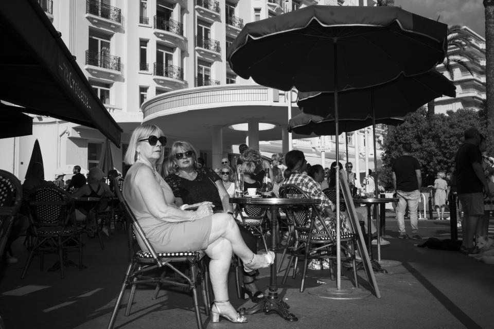 People sit at a cafe on the Croisette during the 75th international film festival, Cannes, southern France, Tuesday, May 24, 2022. (AP Photo/Petros Giannakouris)